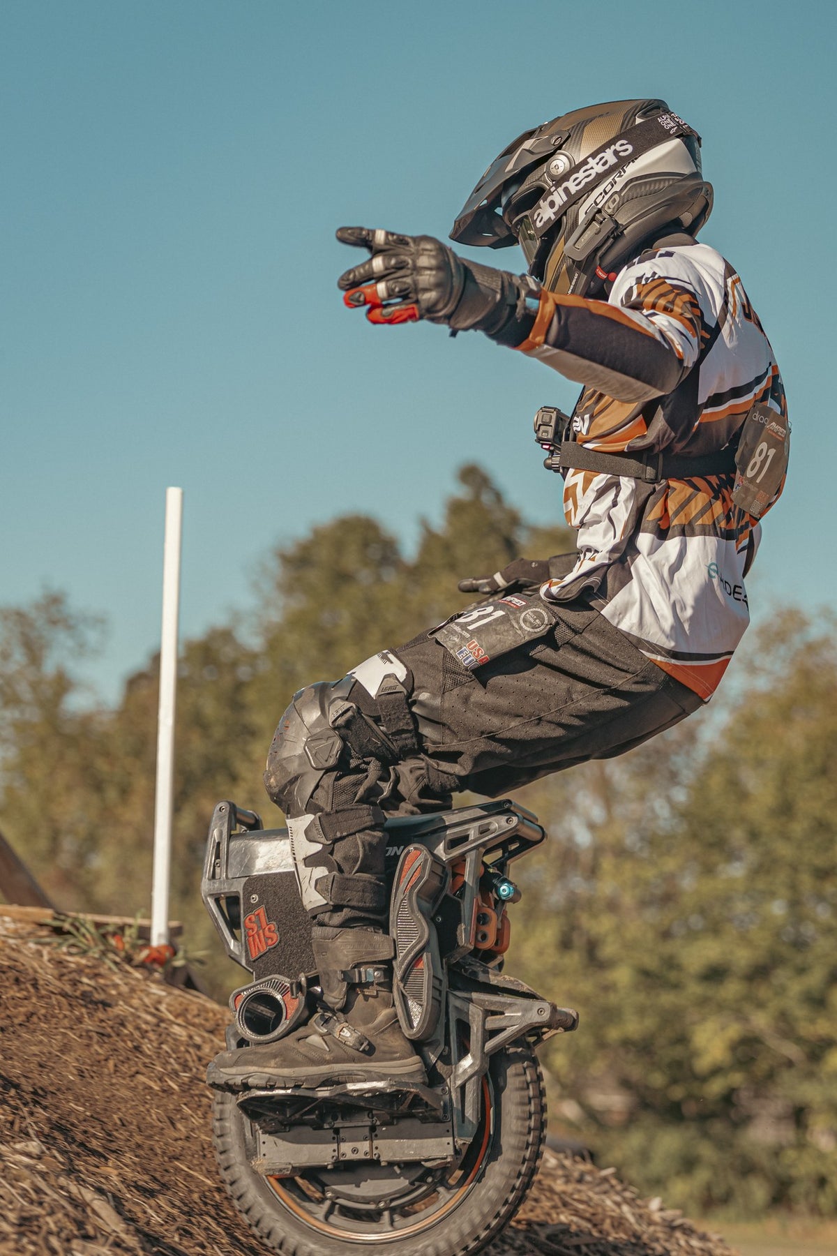 Helmeted rider leaning on an INMOTION X1 on a dirt track in an official manufacturer photograph.